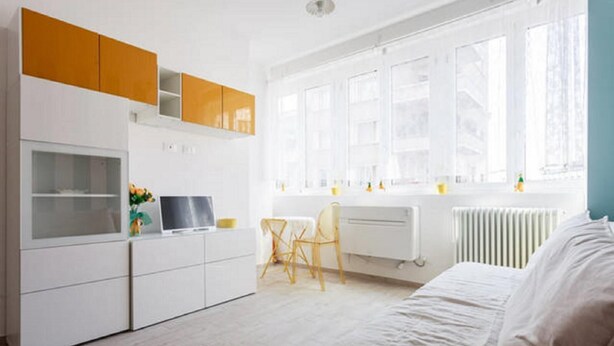 Une chambre à coucher moderne avec un lit, un bureau et un radiateur.