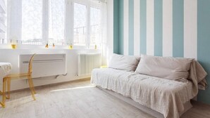Une pièce avec un lit, une chaise, un radiateur et une fenêtre.
