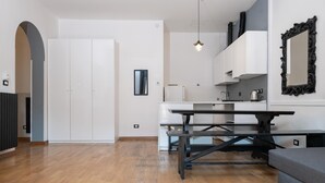 Une cuisine moderne avec des armoires blanches, un comptoir noir et un luminaire suspendu.