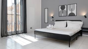 Ein modernes Schlafzimmer mit einem Bett, einem großen Fenster mit Vorhängen und Wandbildern.