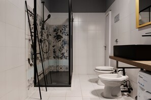 Une salle de bain avec une douche, des toilettes et un lavabo.