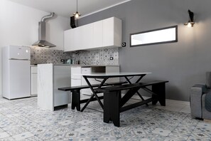 Une cuisine moderne avec des meubles blancs, un îlot central et des carreaux de sol à motifs.