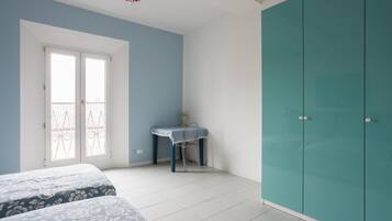 A bedroom with a bed, a desk, and a wardrobe.