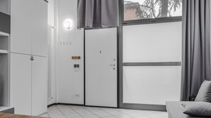 Een moderne, compacte kamer met een bed, bureau en een kledingkast.