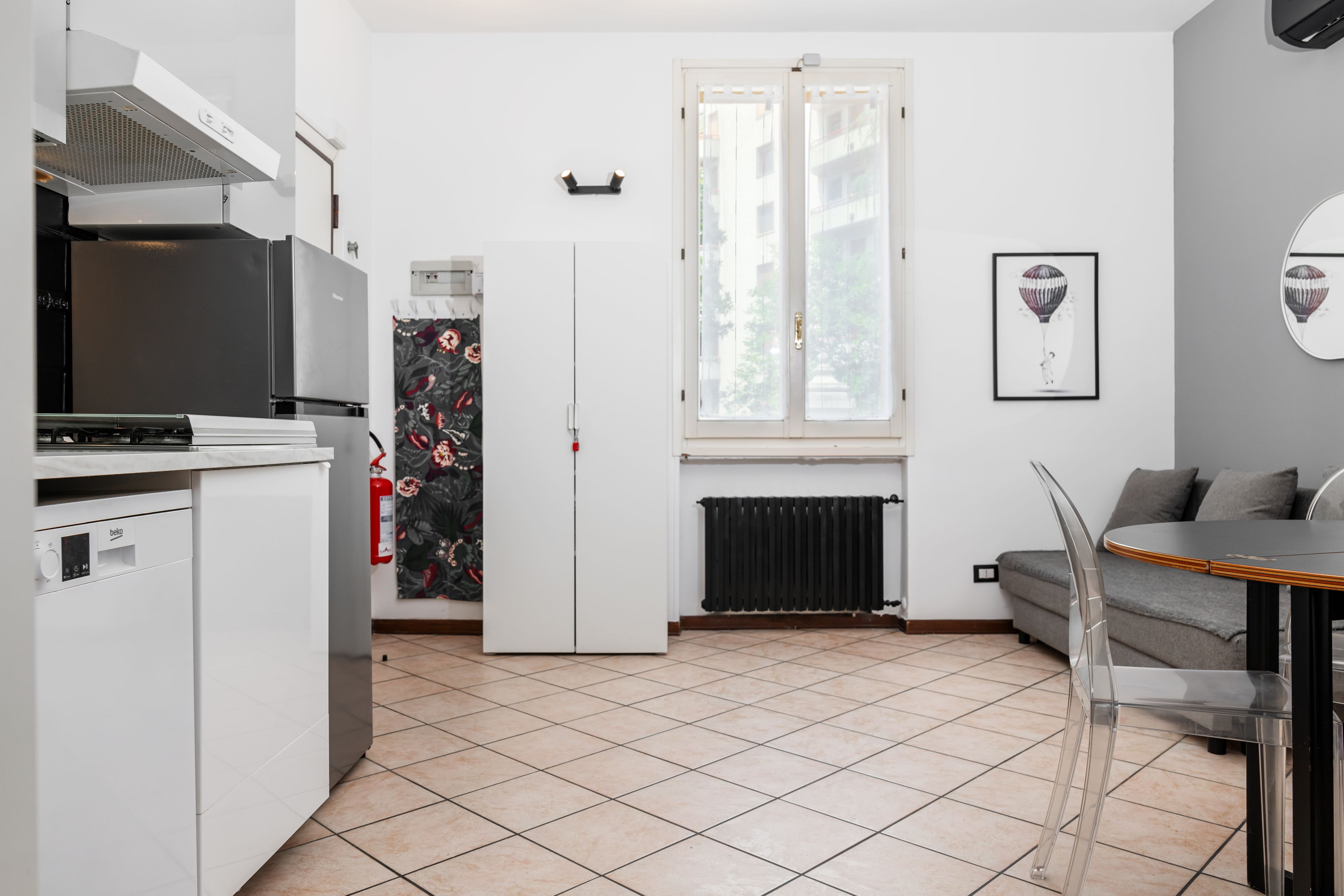 A compact kitchen with a refrigerator, stove, and a dining area with a table and chairs.