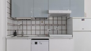 Een praktische keuken met een inbouw vaatwasser, een spoelbak met kraan en een magnetron.