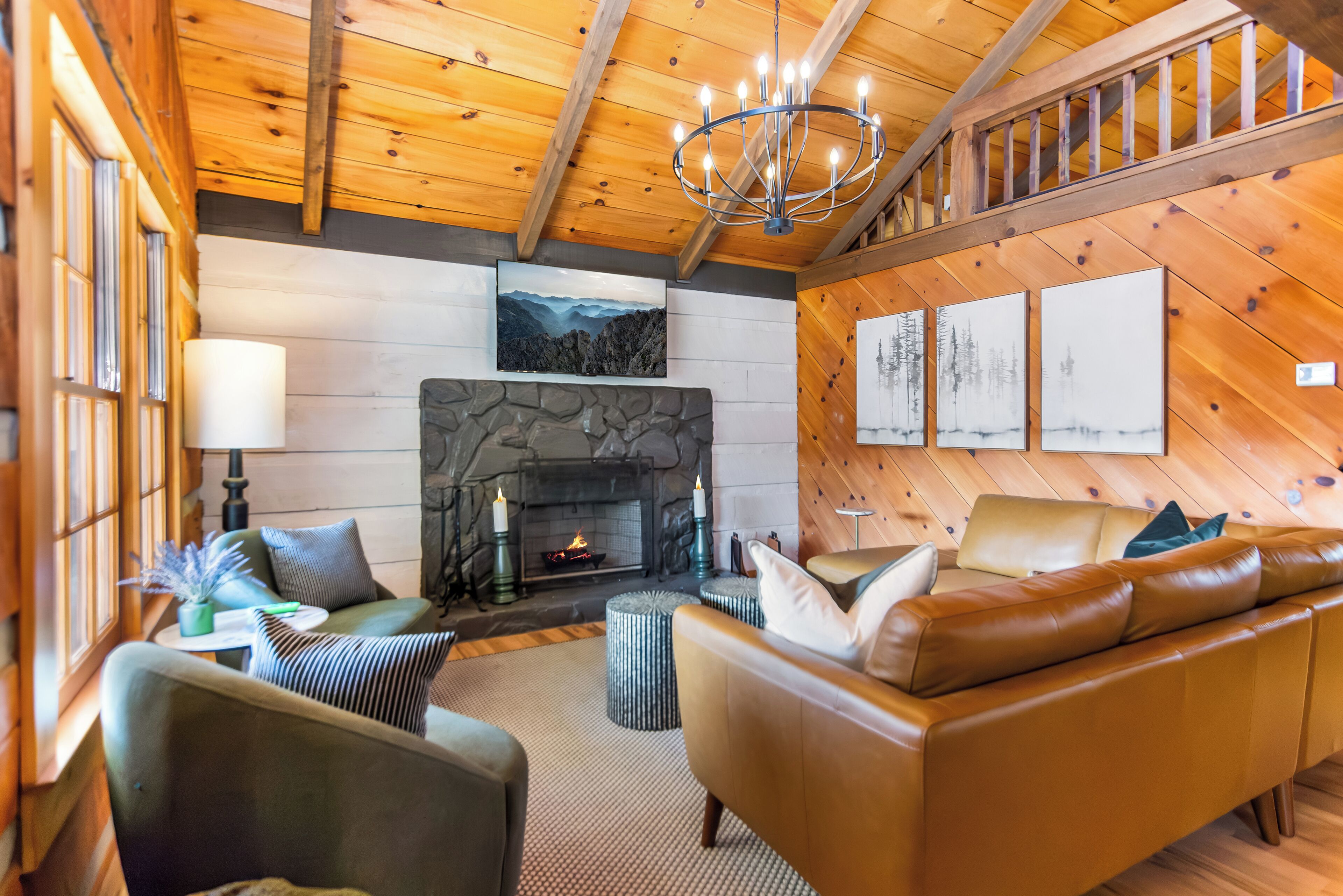 Un salón acogedor con chimenea, sofá de cuero y paredes de madera.