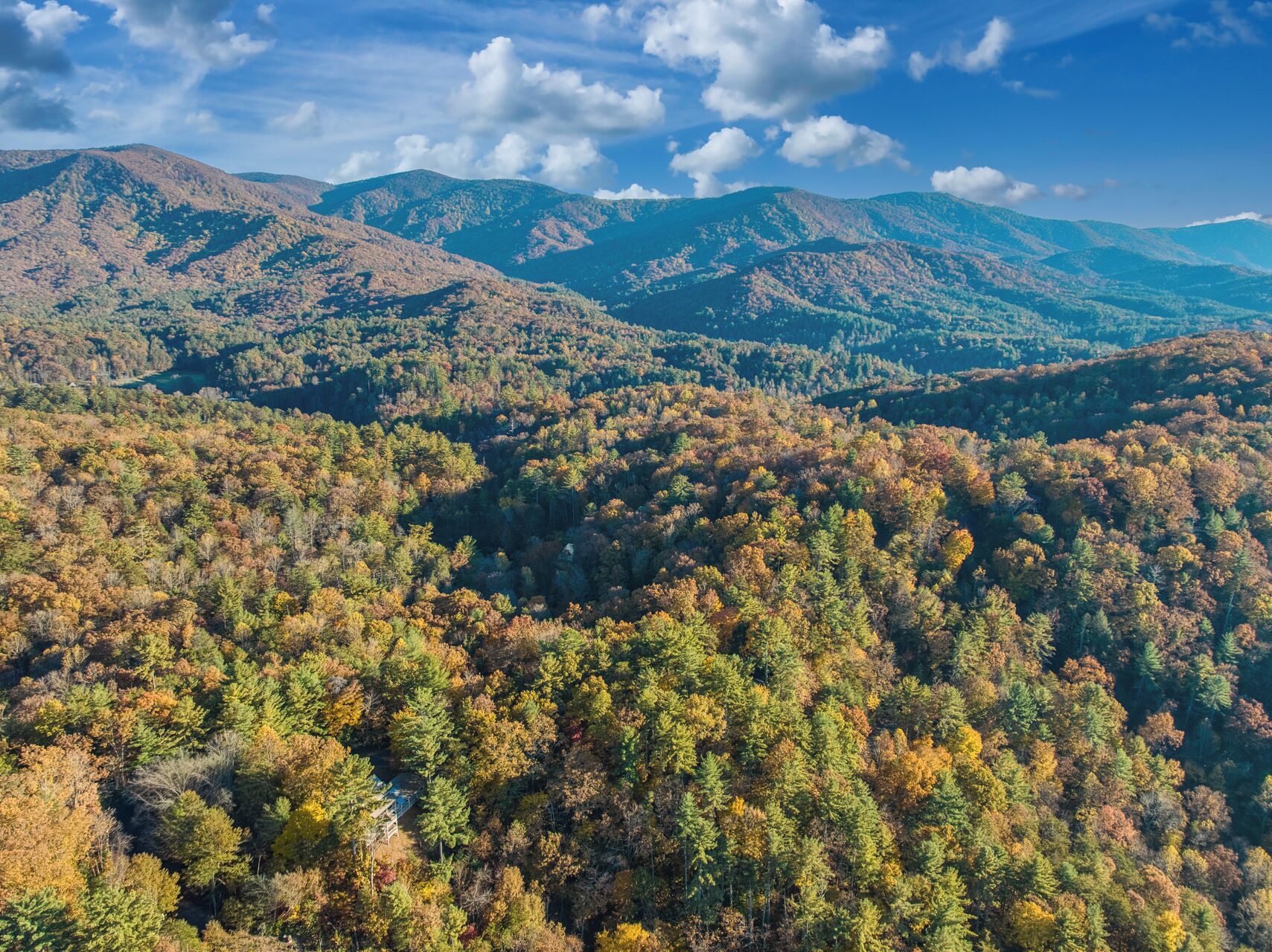 A mountainous landscape with dense forests and a clear sky.