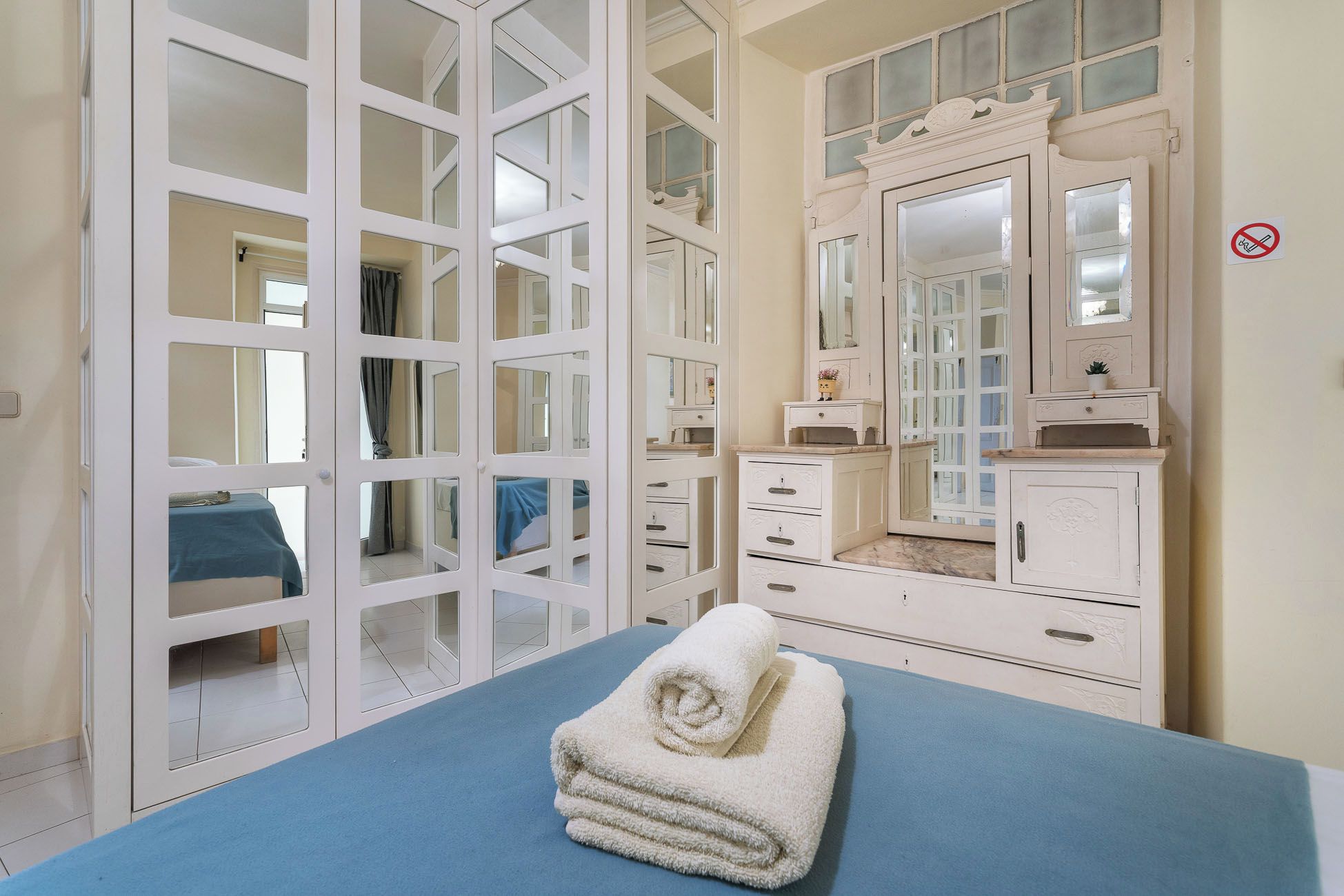 Une chambre avec un lit, une commode, un miroir et une fenêtre donnant sur un beau paysage.