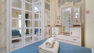 Une chambre avec un lit, une commode, un miroir et une fenêtre donnant sur un beau paysage.