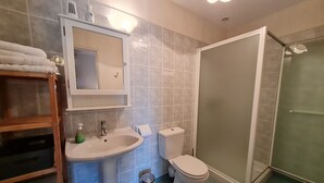 A bathroom with a sink, toilet, and shower.