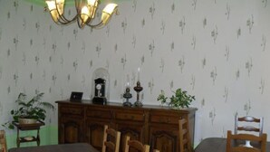 A dining room with a large wooden table, several chairs, a chandelier, a clock, and a cabinet with decorative items. - Stay in the heart of Joan of Arc's land with 4 unique rooms (Montigny-lès-Vaucouleurs)