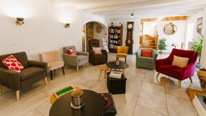 A spacious living area with a sofa, armchairs, a coffee table, and a bookshelf. - Charming mountain B&B rooms, pets allowed with approval (Ventron)