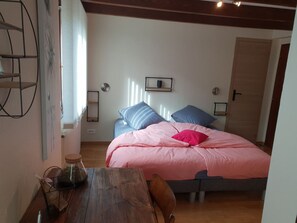 A bedroom with a bed, a wooden table, and a chair. There are two bedside tables with lamps. - Charming mountain B&B rooms, pets allowed with approval (Ventron)