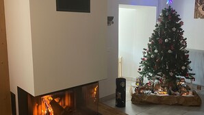 A living room with a fireplace, a Christmas tree, and a small nativity scene. - Charming mountain B&B rooms, pets allowed with approval (Ventron)