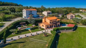 A large estate with multiple buildings, a swimming pool, and well-maintained gardens.