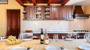 A kitchen with wooden cabinets, a tiled backsplash, and a dining table set for a meal.