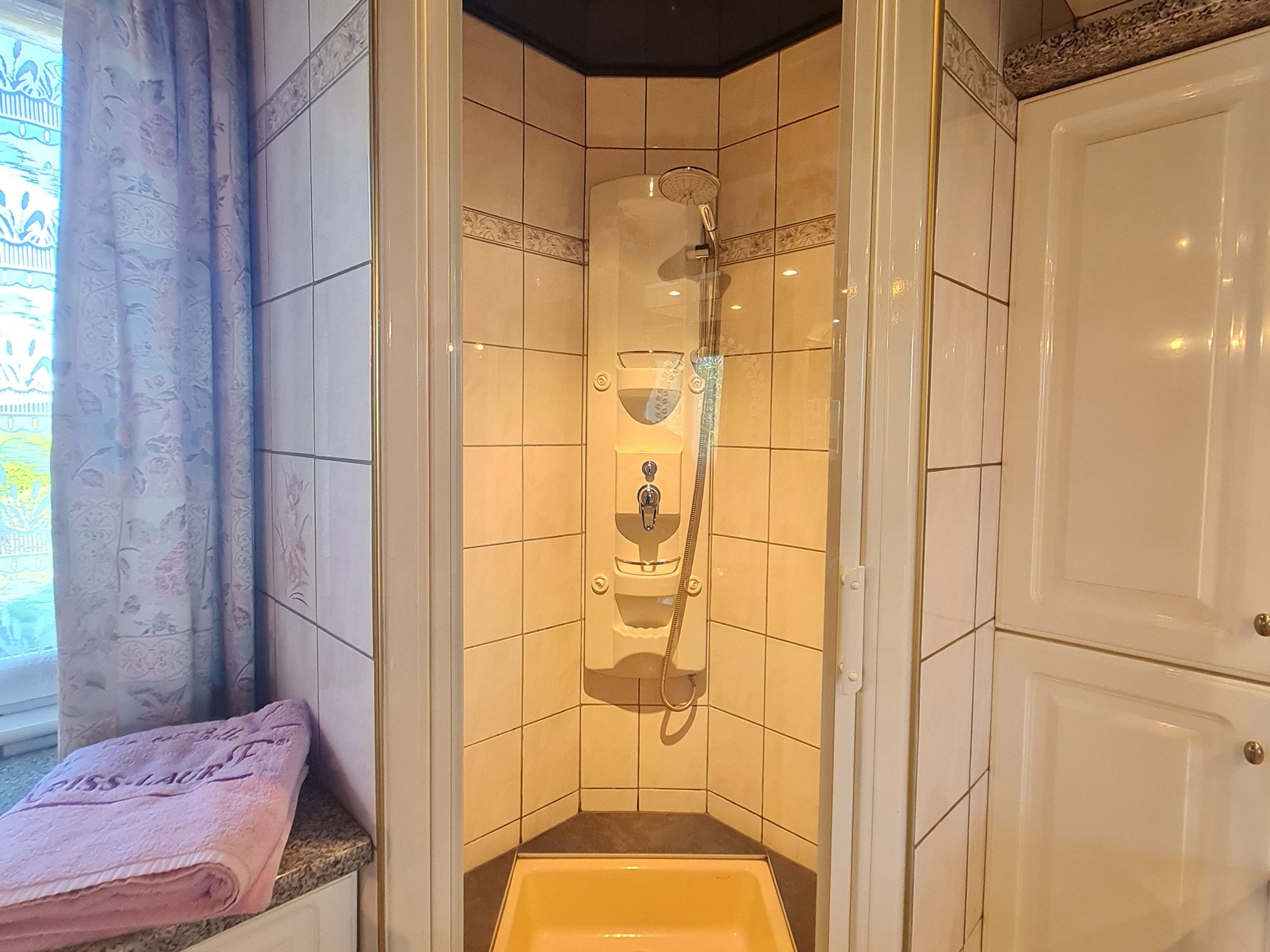 A small bathroom with a shower, a toilet, and a sink.