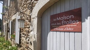 En skylt för ”La Maison sous les Étoiles” som visar att det är ett hotell.