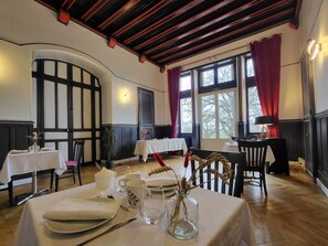 A dining area with tables set for two, featuring white tablecloths and clear glassware. - Elegant stay at Château, modern comfort and nearby activities (Cluis)