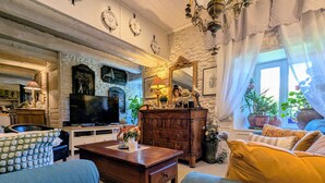 A cozy living room with a fireplace, a television, and a variety of decorative items.