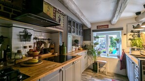 A kitchen with wooden countertops, white cabinets, and a view to the outside.