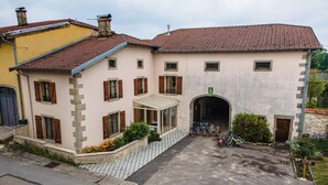 Un edificio con tetto in tegole, un ingresso coperto e una bicicletta parcheggiata davanti.