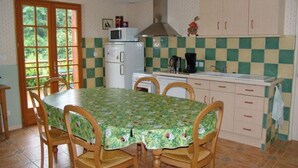 Une cuisine équipée d’une table à manger, de chaises, d’un four à micro-ondes, d’une cuisinière et de placards.