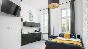 A modern bedroom with a bed, bedside table, and a window with curtains. - RentPlanet - Studio Kępna (Warsaw)