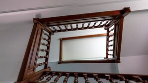 A wooden staircase with a mirror on the wall.