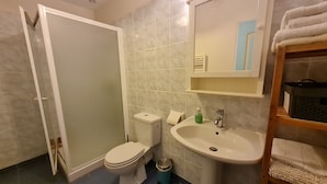 A bathroom with a toilet, sink, and a mirror above the sink. There is a towel rack to the right and a trash bin next to the toilet. - Spacious rooms near Beaugency, breakfast included (Cravant)