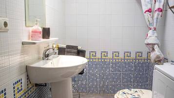 Een douche, handdoeken, zeep, toiletpapier