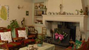 Un salon traditionnel avec une cheminée, des meubles en bois et des objets de décoration.