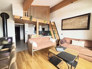 A cozy living room with a sofa, a coffee table, and a fireplace. - Luxury Apartment Les Saisies - 10 Pax, Spa & Parking (Les Saisies)