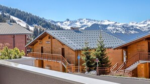 A wooden building with a metal roof, a staircase, and a view of snow-capped mountains. - 4* Apartment with SPA - Les Saisies, 4 ppl, private parking (Les Saisies)