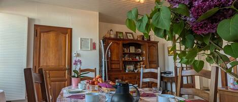 Ein Essbereich mit einem Tisch, der für eine Mahlzeit gedeckt ist, umgeben von Holzstühlen.
