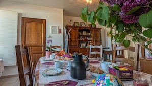 A dining area with a table set for a meal, surrounded by wooden chairs. - Tranquil B&B near Castles and Beauval Zoo (Châtillon-sur-Indre)