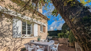 A patio with a table and chairs, surrounded by a brick wall and a tree. - Tranquil B&B near Castles and Beauval Zoo (Châtillon-sur-Indre)