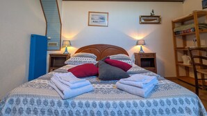 A neatly made bed with patterned bedding and pillows, two bedside lamps, and a wooden headboard. - Tranquil B&B near Castles and Beauval Zoo (Châtillon-sur-Indre)