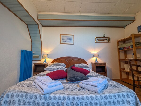 A neatly made bed with patterned bedding and pillows, two bedside lamps, and a wooden headboard. - Tranquil B&B near Castles and Beauval Zoo (Châtillon-sur-Indre)
