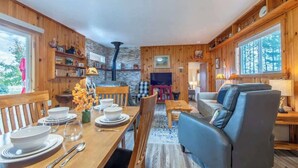 Ein Holzinterieur mit Essbereich, Sofa und Kamin.