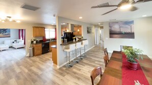 Un espacio habitable amplio con cocina, mesa de comedor y ventilador de techo.