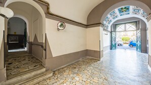 A hallway with a mosaic floor, arched doorways, and a view of the street outside. - Eclectic Apartment 2 in Vasto by Wonderful Italy (Naples)