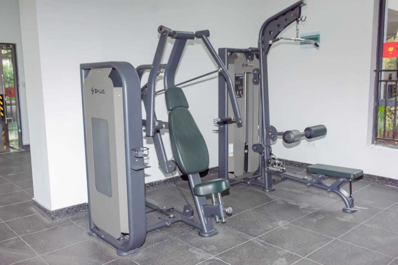 Ett gym med en bänkpress, en sittande bröstpressmaskin och en knäböjsställning.