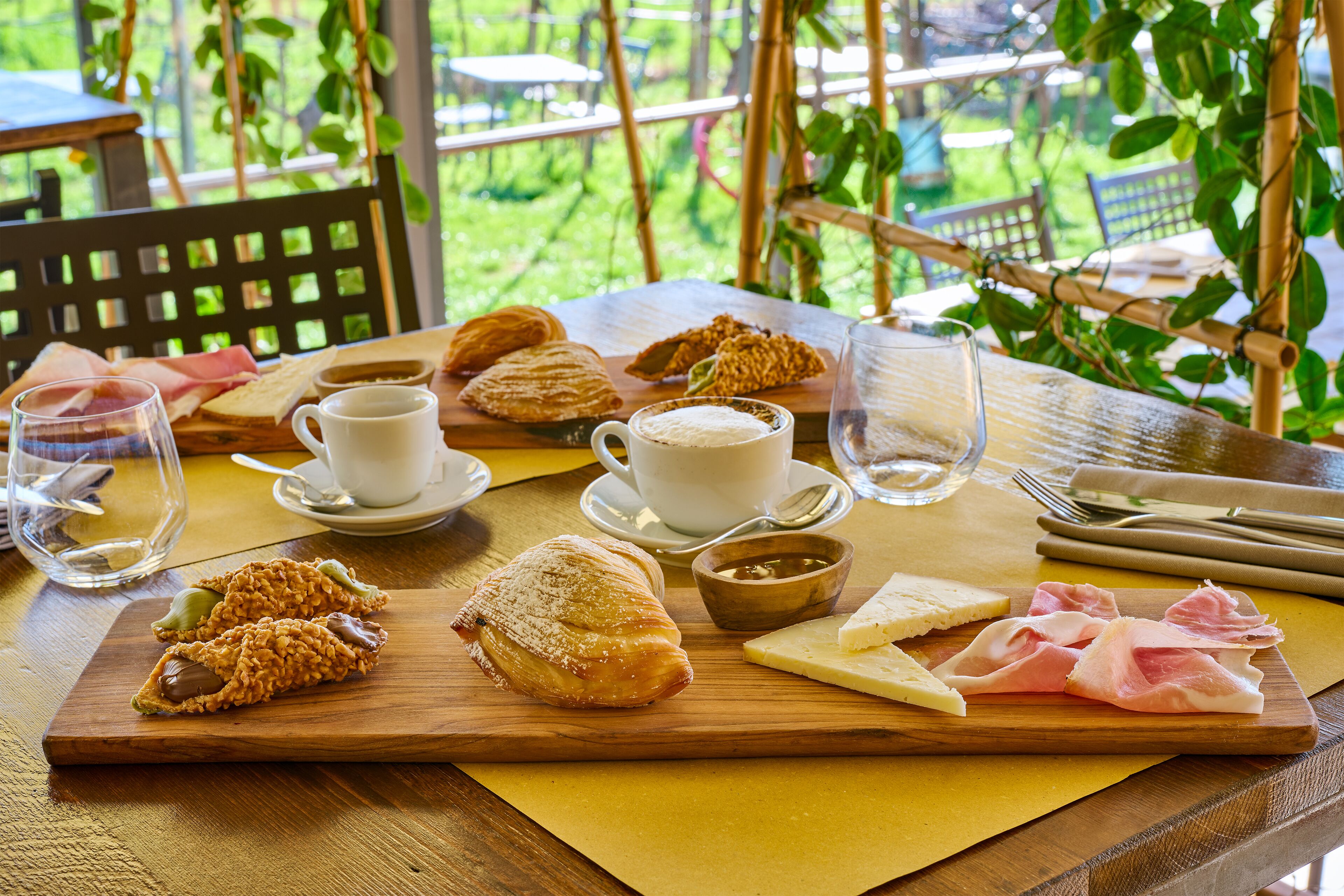 Una mesa de madera con pasteles, una taza de café y un vaso de agua.