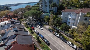A residential area with a multi-story building, a parking lot, and a view of the sea. - Delightful Darling Point Studio w Stunning Rooftop (Darling Point)