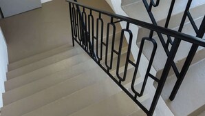 A staircase with black metal railings and beige steps. - Delightful Darling Point Studio w Stunning Rooftop (Darling Point)