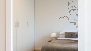 Ein Schlafzimmer mit Bett, Nachttisch, Lampe und Kleiderschrank.