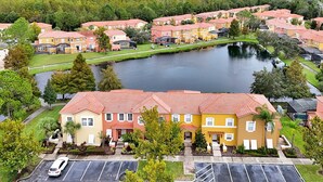 A residential area with multiple apartment buildings, a parking lot, and a lake. - Lakeview Home in Terra Verde:Pool & Resort Amenities (Kissimmee)