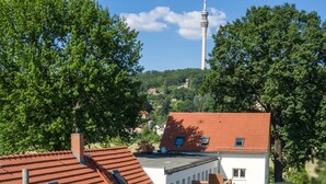 A building with a red-tiled roof, a sign indicating 'Pension Garni No.11', and a view of a tower in the background. - apartment for 4 people with kitchen & balcony, view of the Elbe & free Wi-Fi (Dresden)